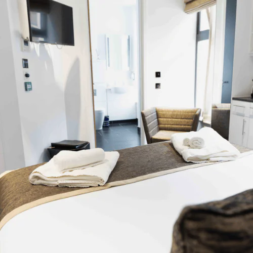 A sophisticated boutique serviced bedroom at Office Space in Town Monument, providing luxury overnight stays within the nautical-themed business center.
