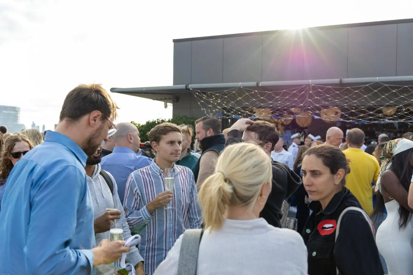 A vibrant corporate summer party on The Deck rooftop at OSiT Monument, featuring guests enjoying premium hospitality and panoramic views of The Shard and Tower Bridge from a luxury yacht-themed terrace.