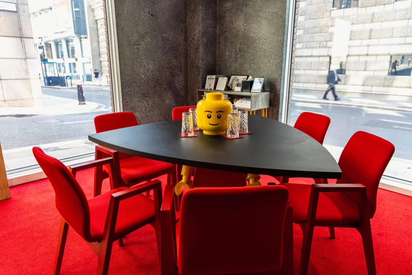 Creative meeting space at Office Space in Town Blackfriars, showcasing the Lego theme with a custom boardroom table, bright red and yellow accents, and a fun, nostalgic atmosphere for brainstorming sessions.